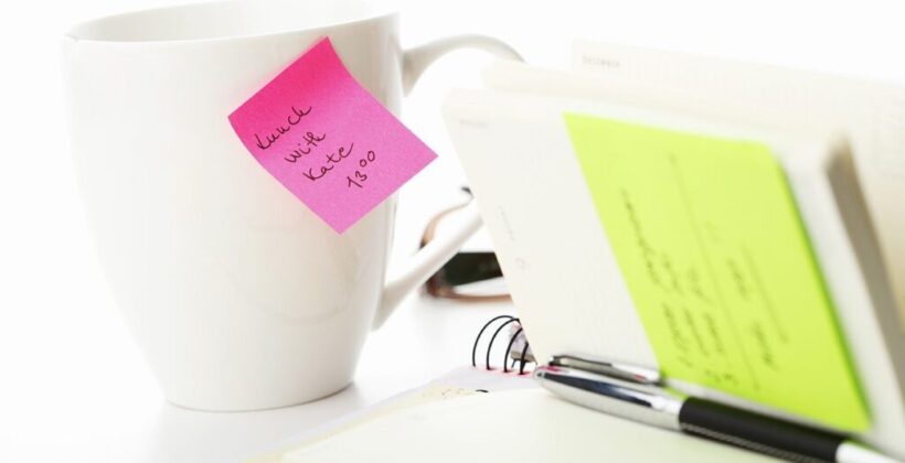 Office yellow and pink sticky note on a coffe cup